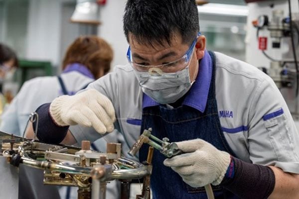 Một nghệ nhân đang hàn các chi tiết kim loại bằng chì không chứa chì.