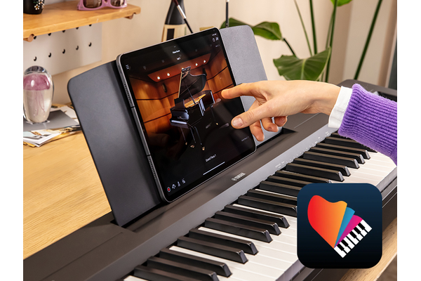 The Yamaha “Smart Pianist” app icon, together with a tablet placed on the music stand of the P-143BT