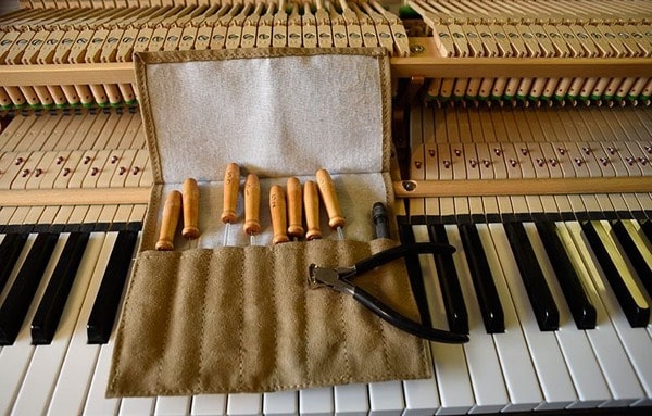 Khi một số bộ phận của phím đàn Piano cơ bị cong vênh, bạn có thể nhờ các kỹ thuật viên chỉnh lại bằng kìm  (Nguồn: Internet)