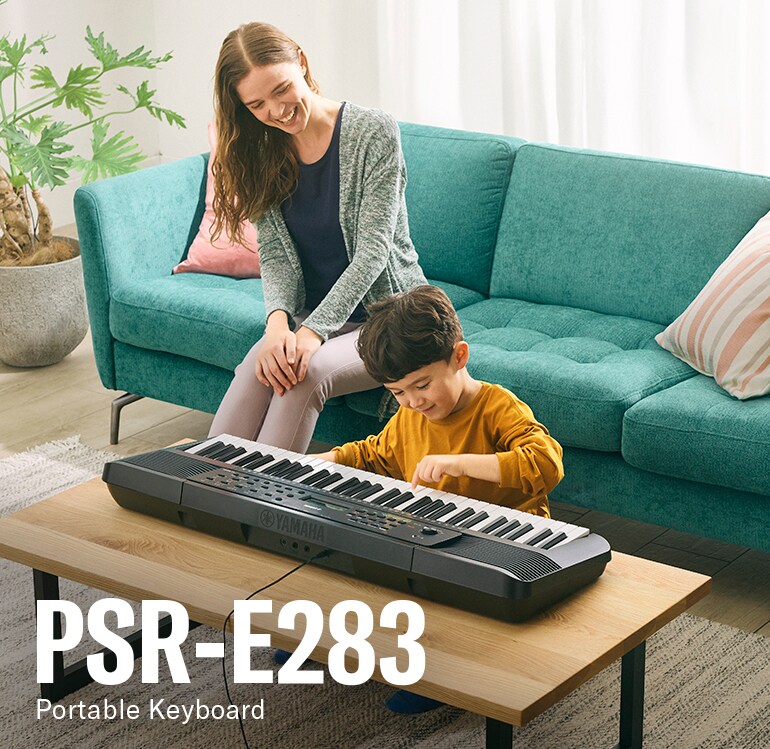 Parent and child happily playing the PSR-E283 on the table