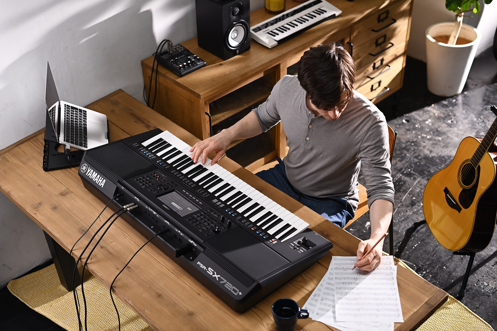 Ảnh chụp một người đang viết nhạc trên đàn Yamaha Arranger Workstation PSR-SX720+.
