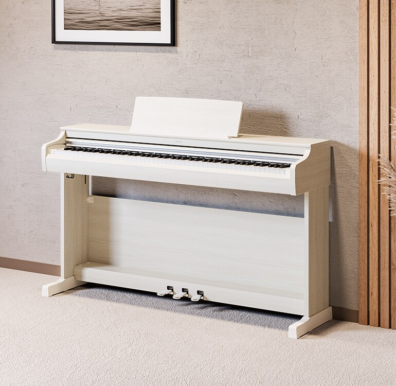 Phòng khách với cây đàn piano ARIUS màu bạch dương trắng, cây cảnh và ghế sofa, được tích hợp hài hòa với nội thất bên trong.