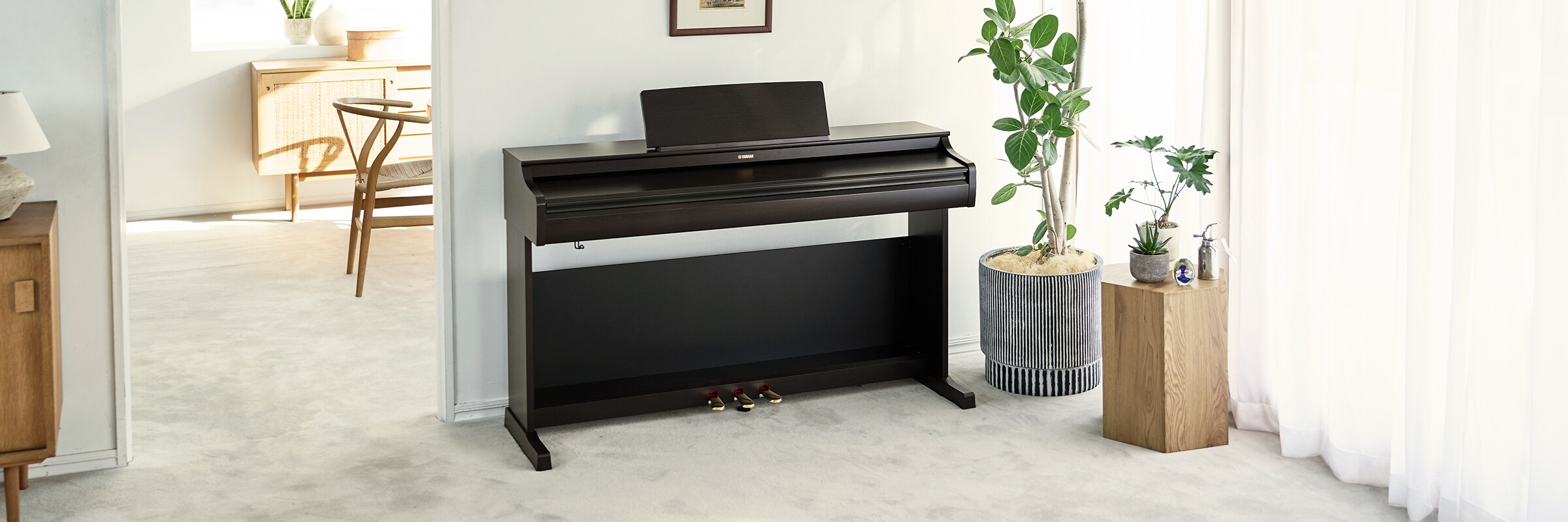 Một chiếc đàn piano ARIUS trong phòng khách với nắp đóng lại, hòa hợp với không gian nội thất.