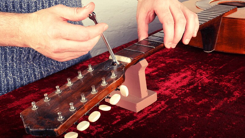 Dùng ti chỉnh cần để vặn cần đàn về lại đúng vị trí ban đầu