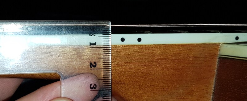 Nếu khoảng cách giữa cần đàn và phím đàn lớn hơn 0,4mm chứng tỏ cần đã bị cong