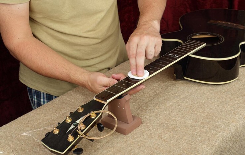 Sử dụng khăn và dầu chanh để lau cần đàn guitar  